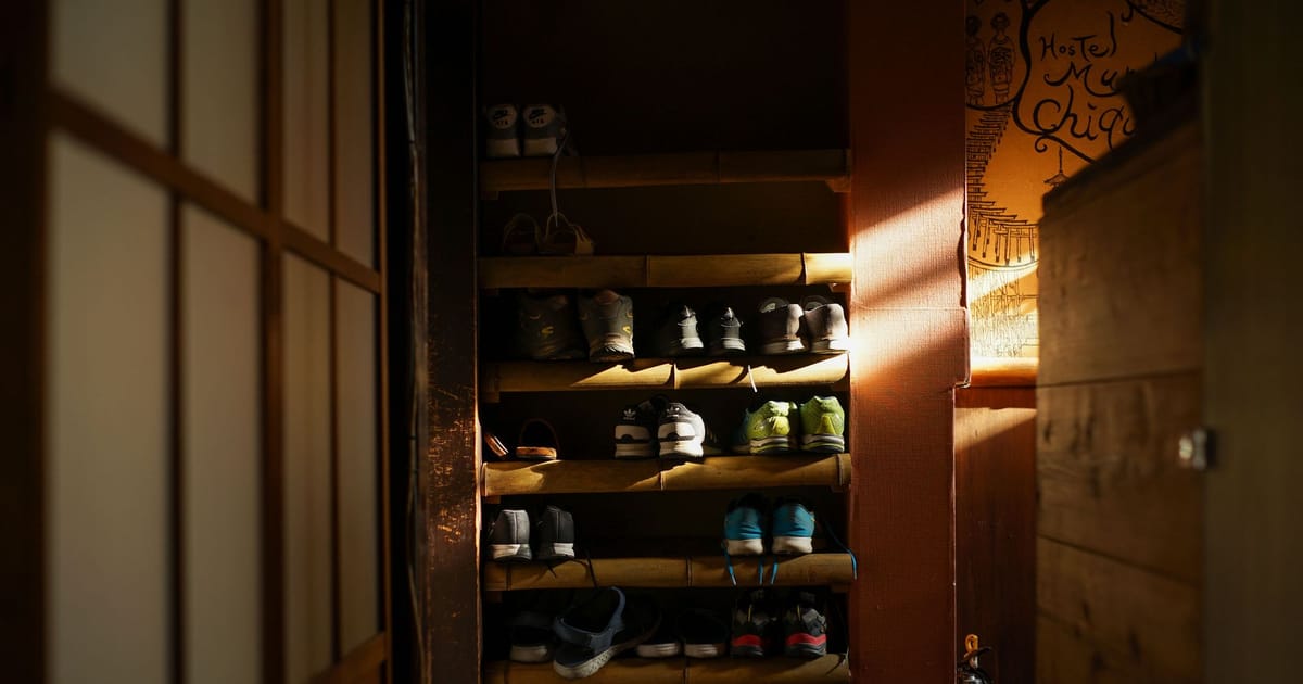 Three pairs of running shoes lined up by a door.